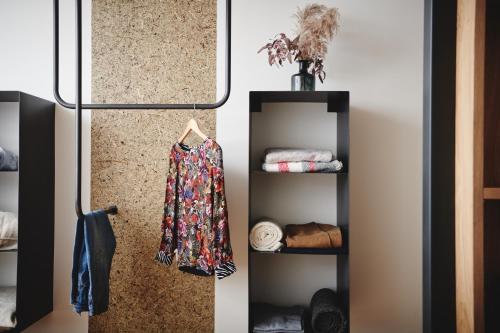 a room with a wall with a shelf with a robe at Quartier am Bauernstadl in Feldbach