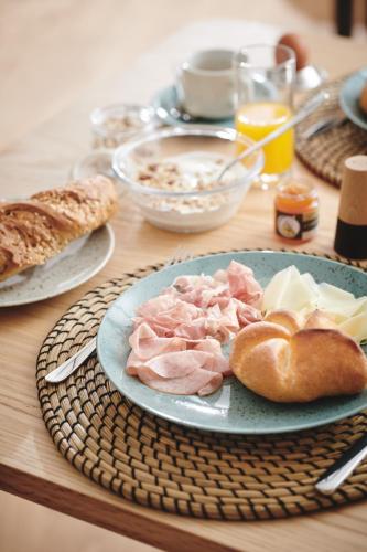 a table with a plate of ham and cheese and bread at Quartier am Bauernstadl in Feldbach