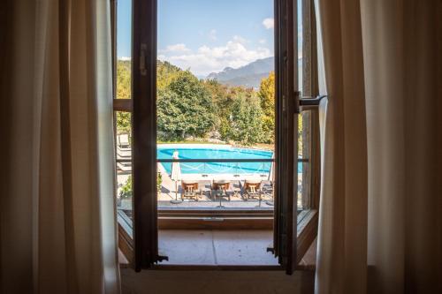 an open window with a view of a swimming pool at Villa Arcadio Hotel & Resort in Salò