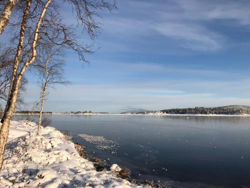 a view of a lake with snow on the shore at Villa Váibmu in Inari