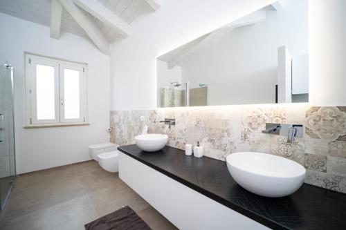 a bathroom with two sinks on a black counter at Villa le Fontanelle in Gasperina