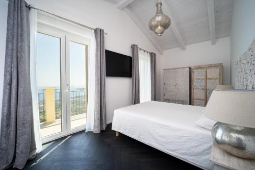 a bedroom with a bed and a large window at Villa le Fontanelle in Gasperina
