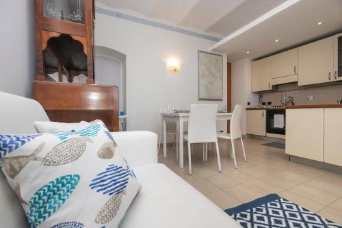 sala de estar con sofá blanco y cocina en Casa sul Mare, en Riva Trigoso