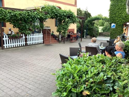 a group of people sitting at a table in a garden at Hotel-Restaurant Christine in Lübz