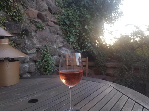 a glass of wine sitting on a wooden table at Woolly Hill House - Beautiful Townhouse in the Heart of Wooler in Wooler