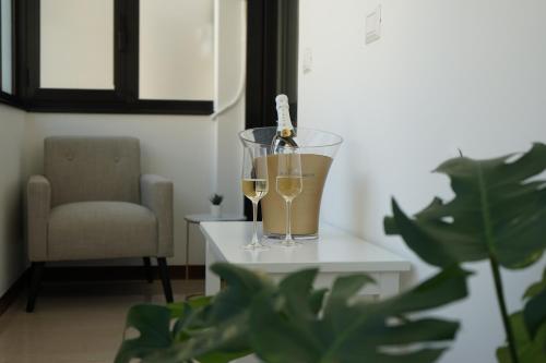 a bottle of wine and two glasses on a table at Room 56 - Le Dimore in Bari