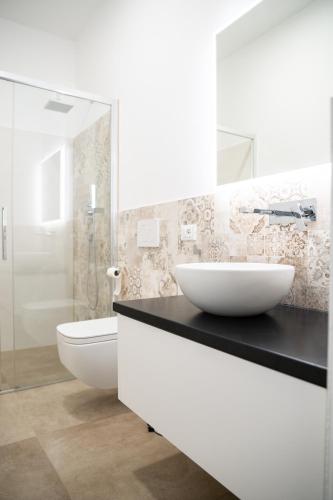a white bathroom with a sink and a toilet at Villa le Fontanelle in Gasperina