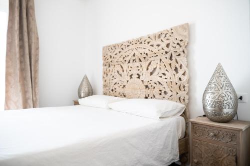 a bedroom with a white bed with a headboard at Villa le Fontanelle in Gasperina