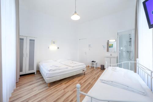 two beds in a hospital room with wooden floors at Timeout City Hotel, 5 min to city center, Self Check In in Vienna