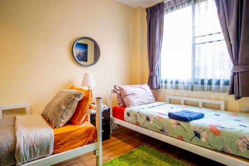 a bedroom with two beds and a window at The Cube Sathorn Boutique Hotel เดอะ คิวบ์ สาทร บูติค โฮเทล Near BTS Surasak in Bangkok