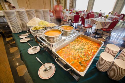 バンコクにあるRoyal Rattanakosin Hotel - Near Grand Palace & Khaosan Roadのレストランのテーブルに並べられたビュッフェ形式の料理