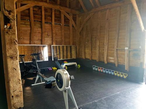 a gym in a wooden barn with a treadmill and weights at Wingfield Escapes in Diss