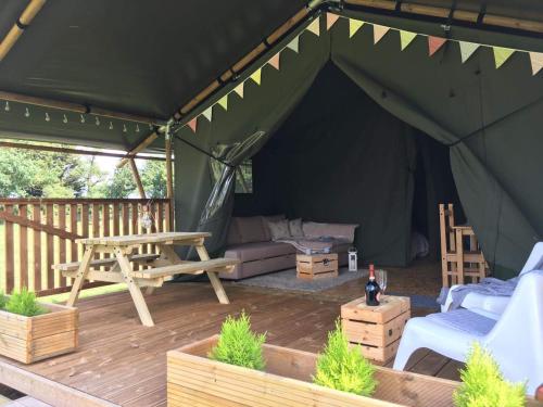 a tent with a couch and a table and chairs at Wingfield Escapes in Diss