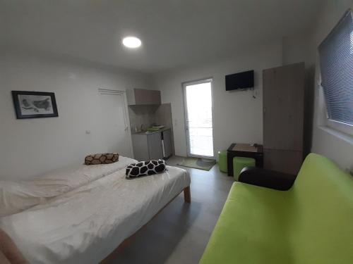 a small room with a bed and a green chair at NULI apartments in Kruševo