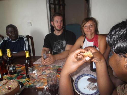 Eine Gruppe von Menschen, die an einem Tisch sitzen und Essen essen. in der Unterkunft MOCAP in Kampala