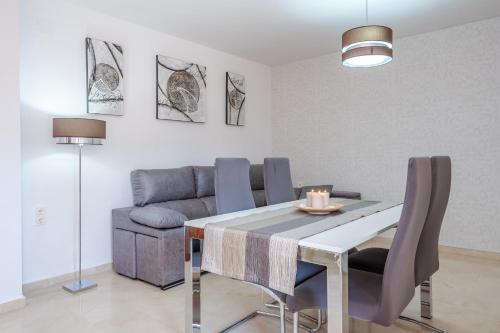 a dining room with a table and a couch at Pianista Apartment Granada by A3Rentals in Granada