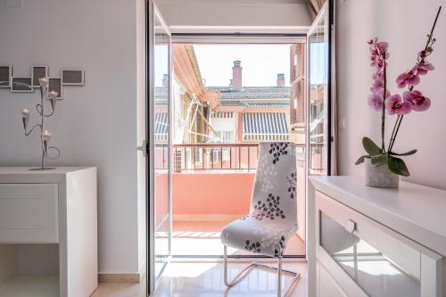 Habitación con silla y balcón. en Pianista Apartment Granada by A3Rentals en Granada