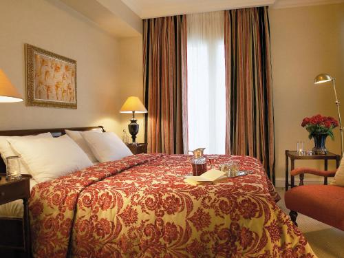 pokój hotelowy z łóżkiem z książką w obiekcie Grecotel Larissa Imperial w mieście Larisa