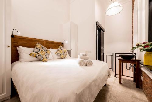 um quarto com uma grande cama branca com almofadas em Villa Kapai em Seminyak