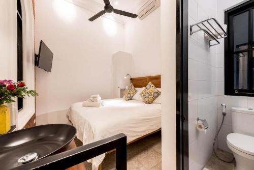 a small bathroom with a bed and a sink at Villa Kapai in Seminyak