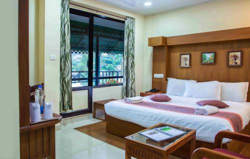 a bedroom with a large bed and a window at Le Celestium in Munnar