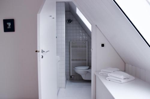 Baño blanco con aseo y lavamanos en Superbe Duplex Penthouse, en Knokke-Heist