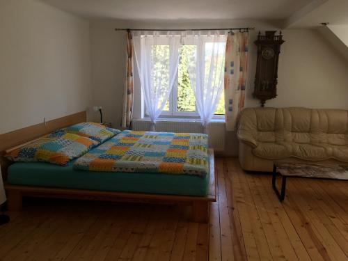 um quarto com uma cama, uma janela e um sofá em Apartment Liberec Stříbrný Kopec em Liberec