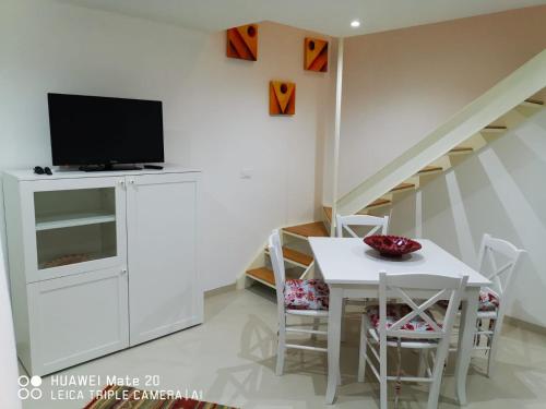 comedor con mesa blanca y TV en CIVICO 63, en Brindisi