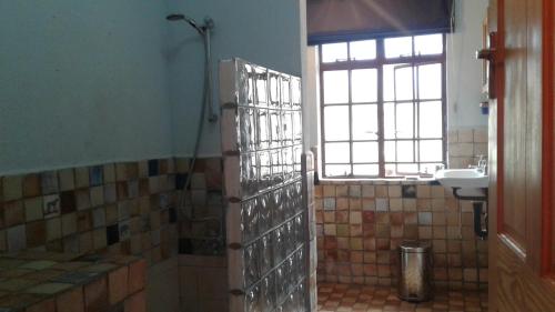 ein Bad mit einer Dusche und einem Waschbecken in der Unterkunft Paz Cottage in Juliasdale