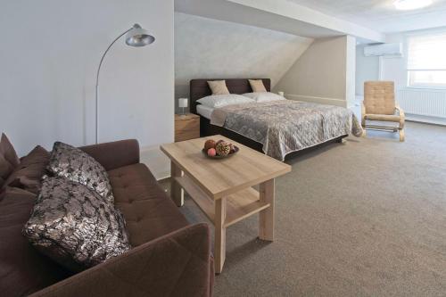 a living room with a couch and a bed and a table at AV Penzion in Olomouc