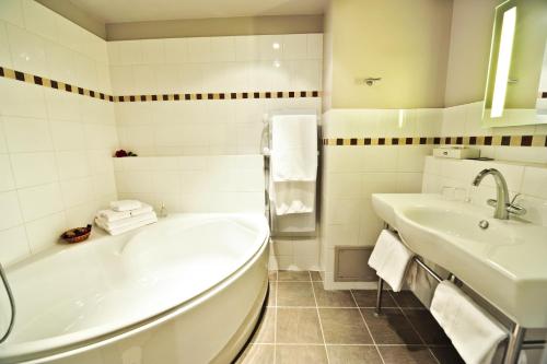 Hôtel Les Esclargies في روكامادور: حمام أبيض مع حوض ومغسلة