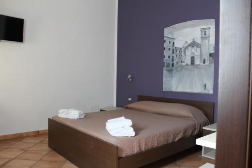 a bedroom with a bed with two towels on it at Room and Breakfast I Gemelli in Iglesias