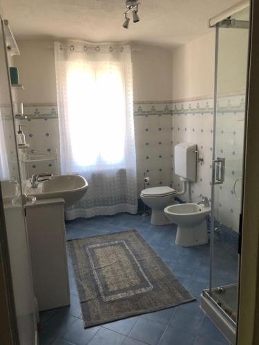 a bathroom with two toilets and a sink and a window at THE BERGHOUSE - LA CASA SUL CLIVO with JACUZZI in Bergamasco