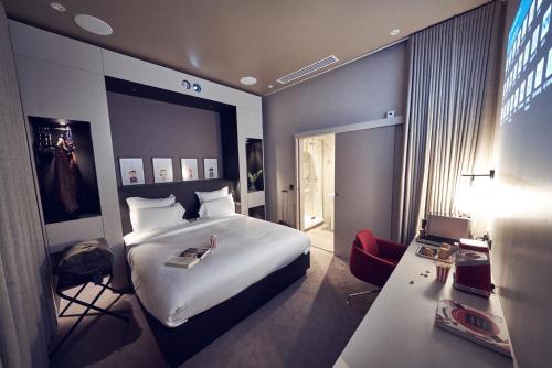 een hotelkamer met een groot bed en een bureau bij Maison Nô - Hôtel et Rooftop in Lyon