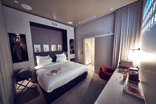 a hotel room with a large bed and a desk at Maison Nô - Hôtel et Rooftop in Lyon