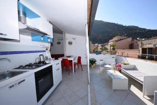 a kitchen and living room with a view of a balcony at Palazzo Taormina in Castellammare del Golfo