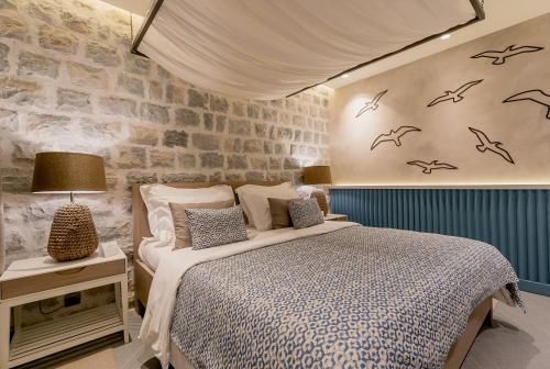 1 dormitorio con 1 cama con pájaros en la pared en Boutique Hotel & Spa Casa del Mare - Mediterraneo, en Herceg-Novi