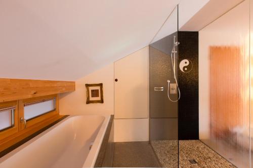 een badkamer met een bad en een douche bij Alpenappartement Bergkönig in Warth am Arlberg