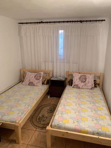 a bedroom with two beds and a window at Casa Pitaru in Calafat