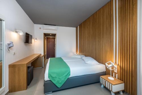 sypialnia z łóżkiem i biurkiem w pokoju w obiekcie Zeus Hotel w mieście Kefalos