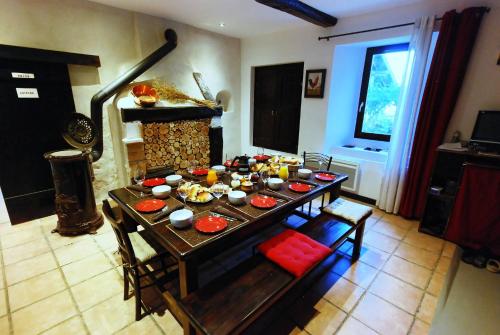 uma sala de estar com uma mesa e uma lareira em Au dessus de Parady em Gillonnay