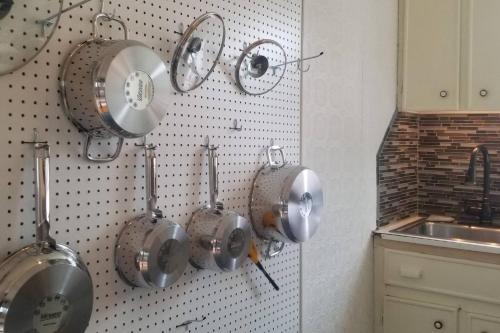 a bunch of pots and pans hanging on a wall in a kitchen at Old School House in Hallowell