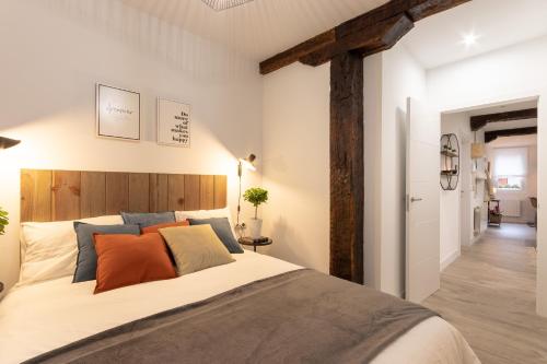 sypialnia z dużym łóżkiem z pomarańczowymi i niebieskimi poduszkami w obiekcie River Apartment in the heart of Bilbao EBI-01297 w mieście Bilbao
