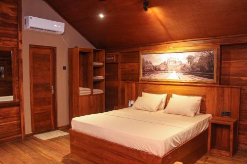 ダンブッラにあるEco Village Kalundewaのベッドルーム1室(ベッド1台付)が備わります。壁には絵画が飾られています。