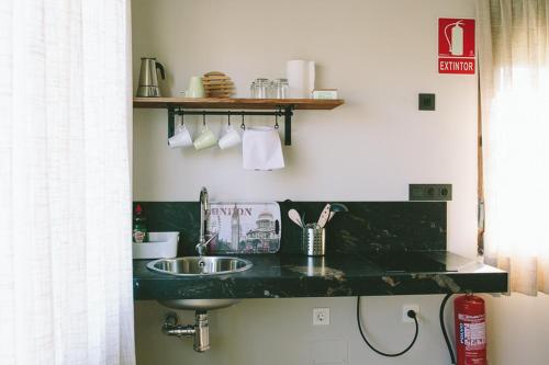 a bathroom with a black counter top with a sink at ALTAIR Turismo Rural in Béjar