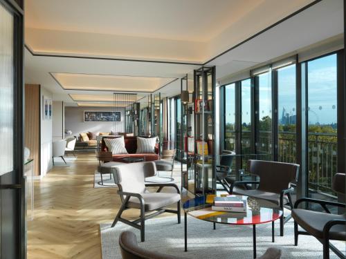 a living room filled with furniture and a large window at The Athenaeum Hotel & Residences in London