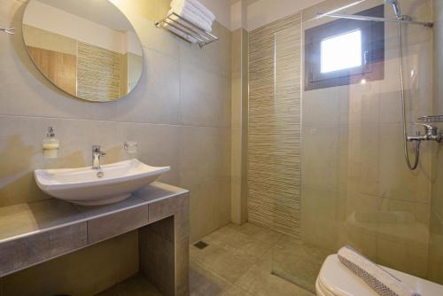 a bathroom with a sink and a mirror and a shower at Villa Ourania in Ierissos