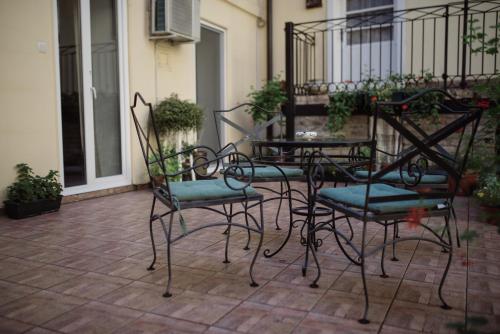 eine Gruppe Stühle und ein Tisch auf einer Terrasse in der Unterkunft Apartmani Maximus in Subotica