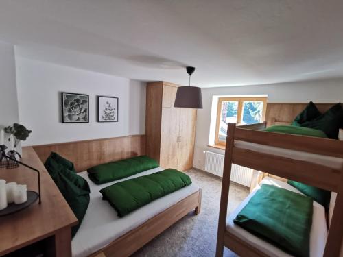 a bedroom with two bunk beds with green pillows at Ferienwohnung Hirscher in Annaberg im Lammertal
