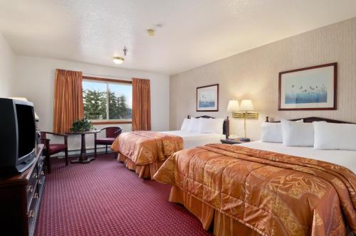 a hotel room with two beds and a flat screen tv at Travelodge by Wyndham Juneau in Mendenhaven